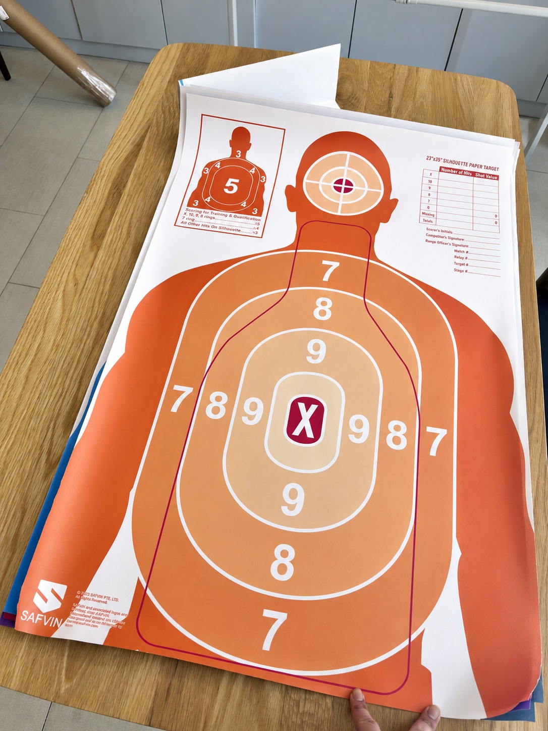 Actual orange SAFVIN paper target laid out on a table